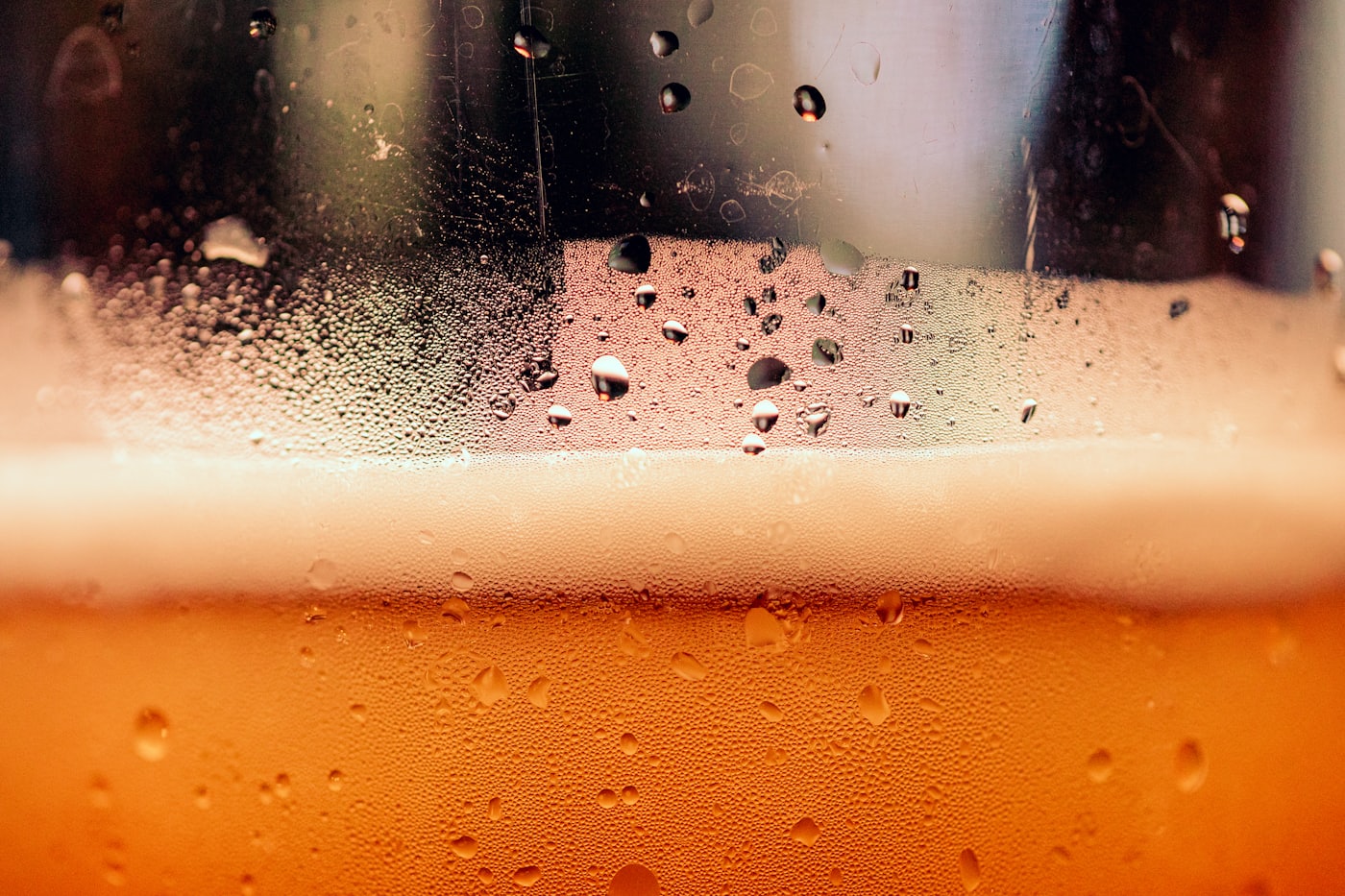 A close-up of a cold amber draught beer, foam and condensation on the glass — placeholder photo