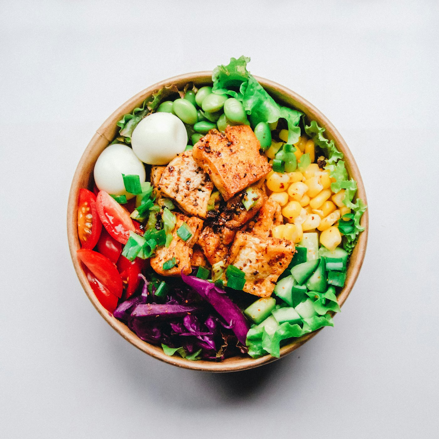 A colourful poke-style bowl with cubed protein, edamame, corn, cucumber and greens — placeholder photo, not the Axe & Anchor’s kitchen