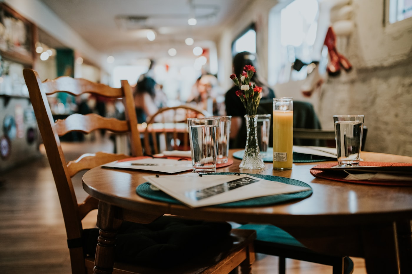 A warm, rustic table set with wooden chairs, glasses and a candle in a small-town room — placeholder photo, not the Axe & Anchor’s room