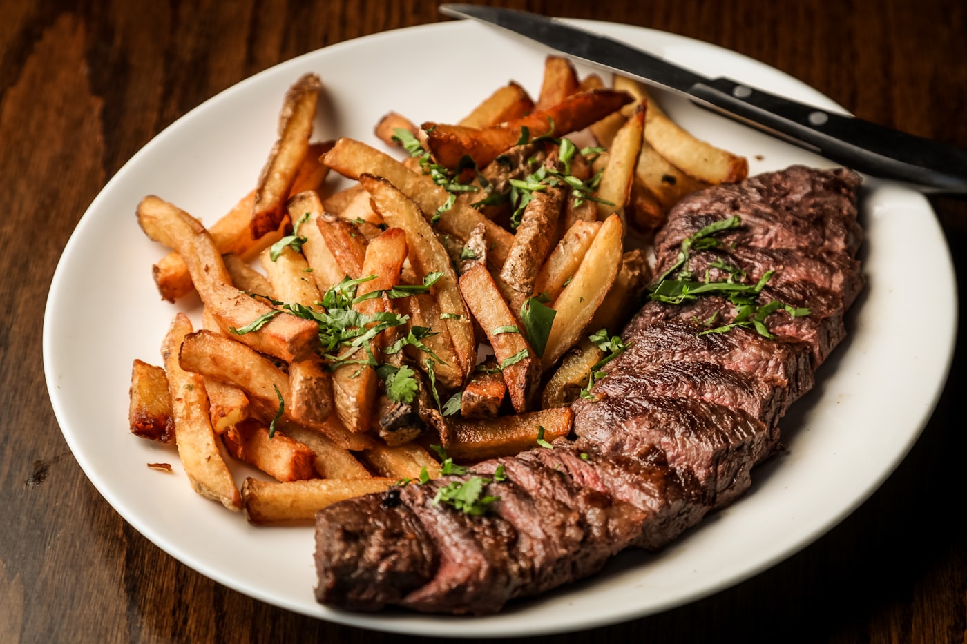 A grilled steak plated with hand-cut fries and herbs — placeholder photo, not the Axe & Anchor’s kitchen